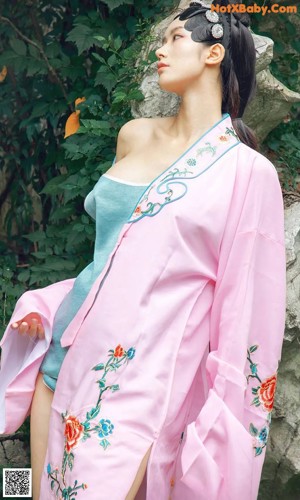 A woman sitting on a wooden bench next to a lotus flower.