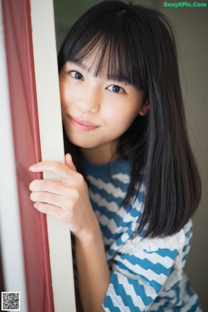 A woman in a white dress sitting on a window sill.