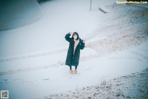 A woman wearing a face mask in the snow.