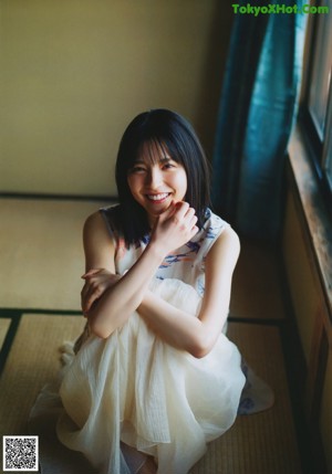 A woman with long black hair is posing for a magazine.