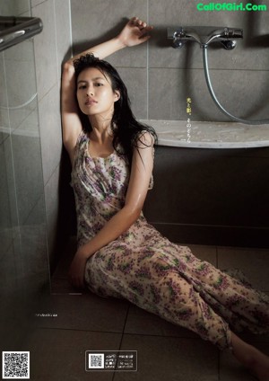 A woman sitting in a bathtub in a bathroom.