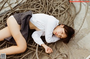 A woman in a white shirt and plaid skirt standing on a roof.