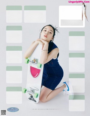 A woman in a blue dress is posing for a magazine.