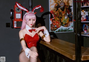 A woman in a bunny costume sitting on a bar.