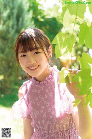 A girl in a pink dress is posing for a picture.