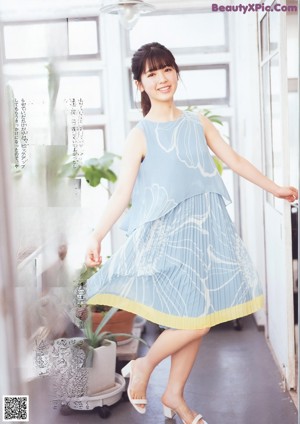 A magazine page with a picture of a woman in a blue dress.