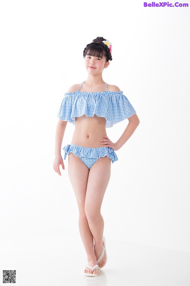 A woman in a blue and white gingham bikini posing for a picture.