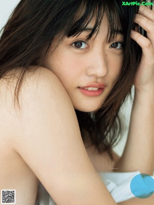 A woman in a bikini sitting in the water.