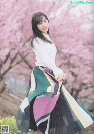 A woman in a white sweater is posing for a picture.
