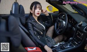 A woman sitting in the driver's seat of a yellow car.