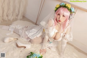 A woman in a wedding dress sitting on a bed.