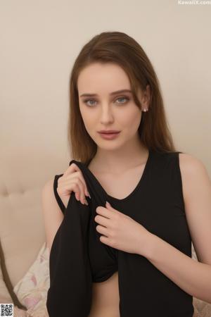 A young woman in a pink top and skirt posing for a picture.