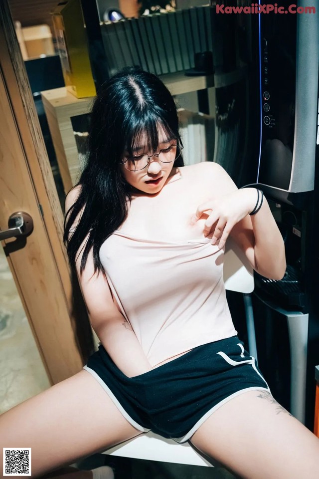 A woman sitting on a chair in front of a coffee machine.